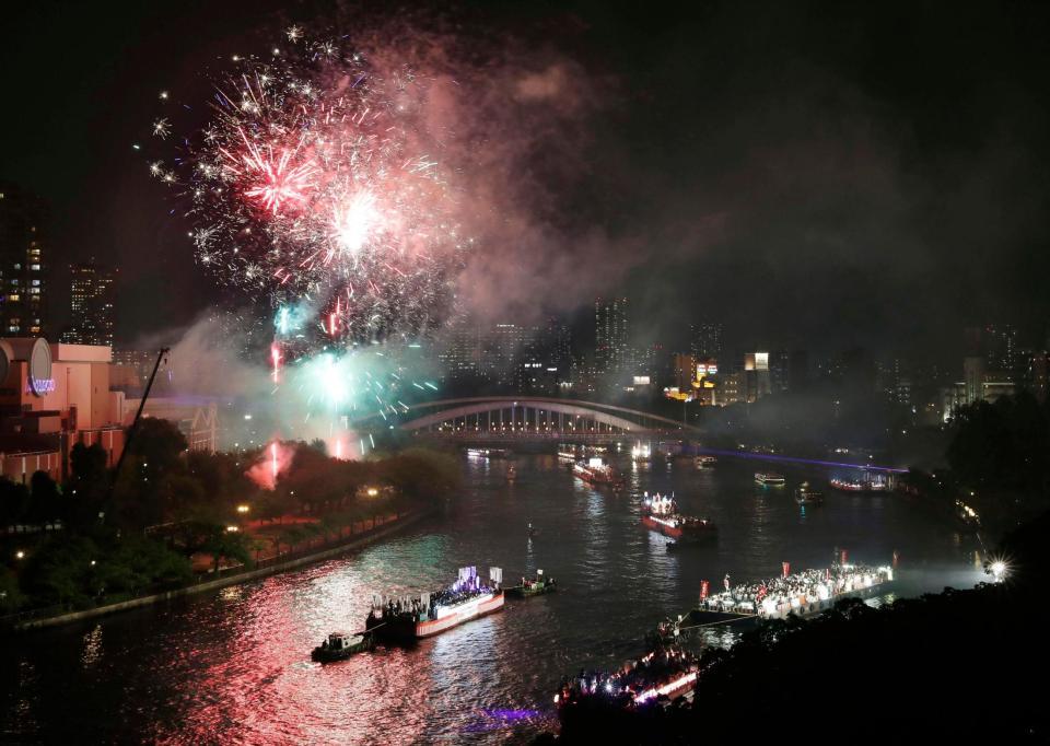 夜空を染める奉納花火の下、大川を船が行き交う天神祭の「船渡御」＝25日夜、大阪市