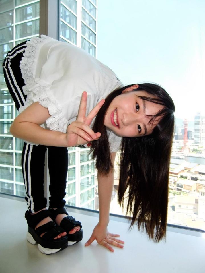 ポートタワーを背景に特技の体前屈を披露する内田珠鈴＝神戸市のデイリースポーツ