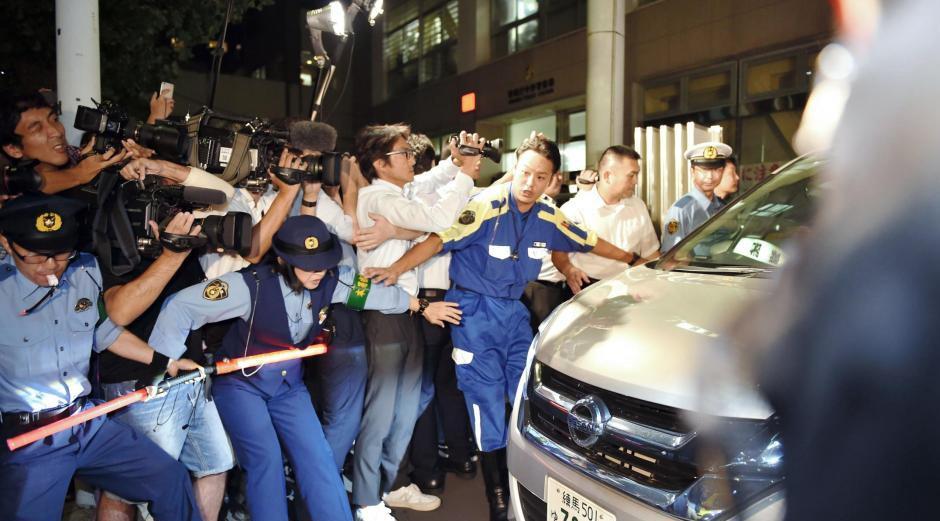 もみくちゃになりながら警察署を出発する吉澤ひとみ容疑者乗せた警察車両＝東京・中野警察署（撮影・西岡正）