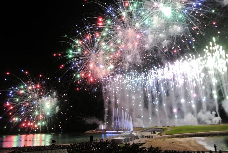 　１万５０００人で埋まった客席のすぐそばで打ち上がる大輪の花火＝沖縄・宜野湾トロピカルビーチ