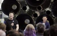 　米宇宙ベンチャー「スペースＸ」のイーロン・マスク最高経営責任者（左）と大型ロケットで月旅行する契約を初めて結び笑顔の前沢友作氏＝17日、米カリフォルニア州（ＡＰ＝共同）