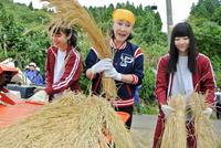 脱穀作業を行う小林幸子（中）とＮＧＴ４８の本間日陽（左）、日下部愛菜＝新潟・山古志