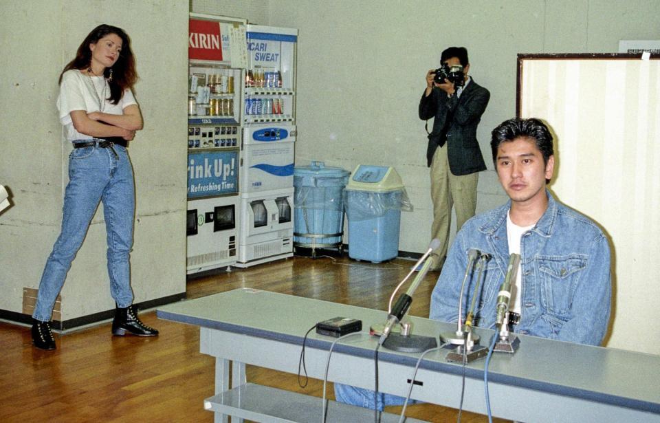 　女優との不倫について会見する川崎麻世（右）を腕組みして監視するカイヤ＝１９９３年