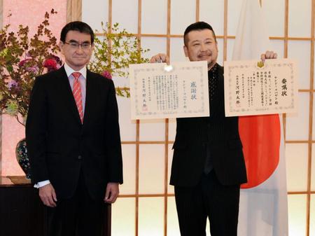 河野太郎外相（左）から感謝状と委嘱状を受け取ったケンドーコバヤシ＝東京・霞ヶ関の外務省