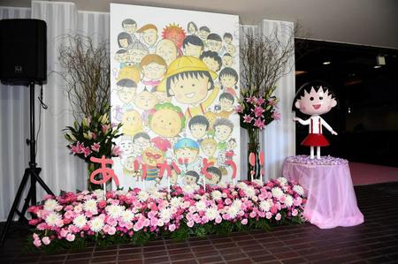 ２０１４年さくらももこのデビュー３０周年を記念して開催された原画展「さくらももこの世界展」のキービジュアル（左）とちびまる子ちゃんの人形（撮影・開出牧）