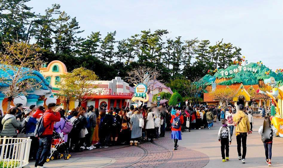 東京ディズニーランドの「ミッキーの家とミート・ミッキー」（右奥）に並ぶ来園者＝18日午前、千葉県浦安市
