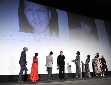 舞台あいさつで１９歳の時の写真（スクリーン左）を公開され苦笑いのＡＫＩＲＡ（中央）＝東京・ＴＯＨＯシネマズ日比谷（撮影・開出牧）