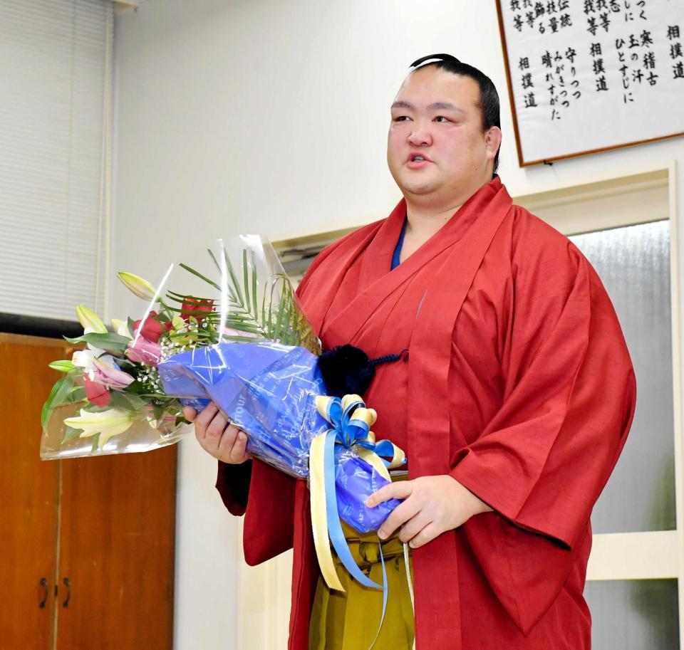 　報道陣から贈られた花束を手にする稀勢の里（撮影・中田匡峻）