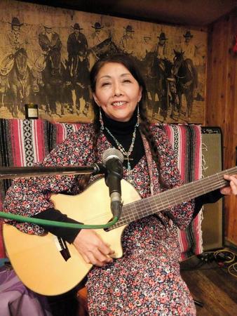 ギターをつま弾く桑名晴子＝兵庫県西宮市の「イエローリボン」
