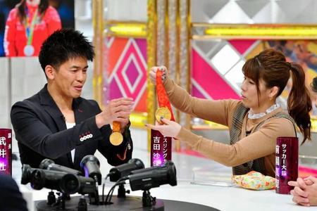 　「戦え！スポーツ内閣」で、武井壮（左）にメダルを見せる吉田沙保里さん