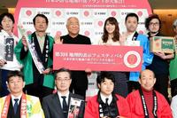 出展事業者と記念撮影に納まる服部幸應氏（中央左）と安めぐみ＝東京・ＫＩＴＴＥ（撮影・開出牧）