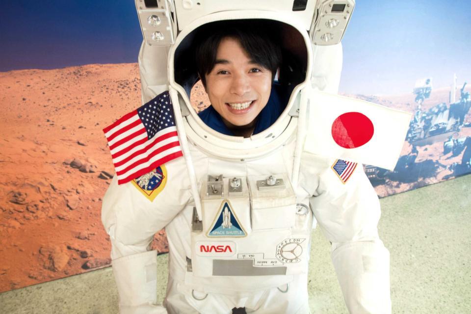 　火星と地球をバックに宇宙服に入る井ノ原快彦＝米アラバマ州のスペースアンドロケットセンター