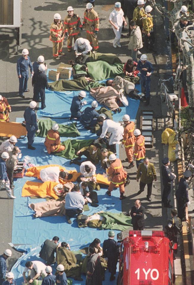 健康被害はいまだに…９５年３月２０日午前、地下鉄日比谷線築地駅前の路上で手当てを受ける地下鉄サリン事件の被害者（提供・共同通信社）