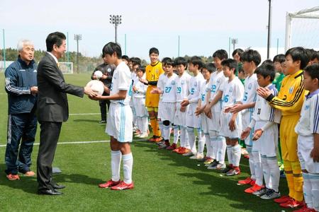 　地元サッカーチームの選手にボールを手渡す安倍首相（左から２人目）＝福島県のＪヴィレッジ（代表撮影）