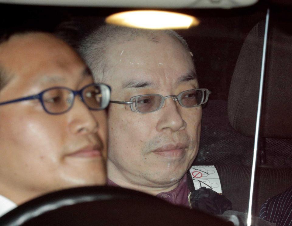 　逮捕され警視庁大塚署に入る自称長谷川薫容疑者（右）