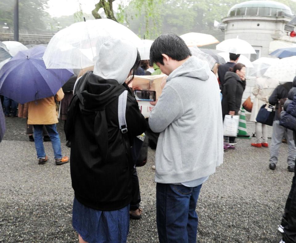 　二重橋前には「天皇陛下最後のお言葉」のライブ中継に耳を傾ける人が多く見られた＝東京・皇居前