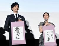 新時代への抱負を記した掛け軸を披露する松坂桃李（左）と木村文乃＝都内