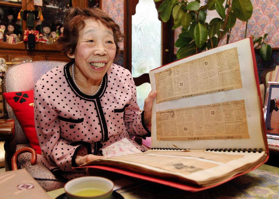 　過去の新聞記事を振り返って笑顔を見せる田辺聖子さん＝２０１１年