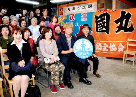 大漁旗が飾られた市場内での上映会に登場した香取（中央右）と白石監督（右端）　