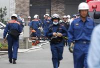 　火災があった「京都アニメーション」のスタジオ付近で活動する消防隊員ら＝18日午後１時４分、京都市伏見区