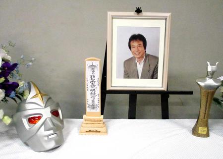 　「石田信之を偲ぶ会」の祭壇に飾られた遺影とミラーマンのマスク
