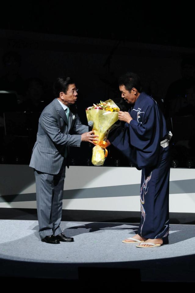 サプライズで駆けつけた友人の西川きよし（左）から花束を受け取る五木ひろし＝大阪・オリックス劇場