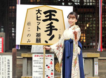 　「王手！」のパネルを手にポーズを決める杜このみ＝東京・千駄ヶ谷の鳩森八幡神社