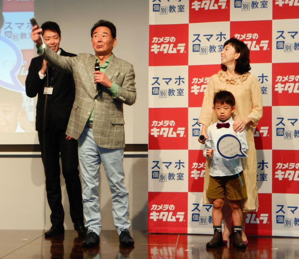 自撮りに挑戦する東尾修氏（左を見守る東尾理子（右）と理汰郎くん＝東京・日本橋