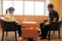 　踏み台に足を乗せ、山本賢太郎五段（右）との対局に臨んだ仲邑菫初段＝大阪市・日本棋院関西総本部