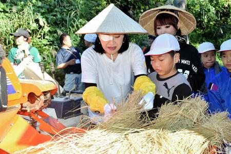 小学生と脱穀を行う小林幸子（中央）＝新潟県長岡市