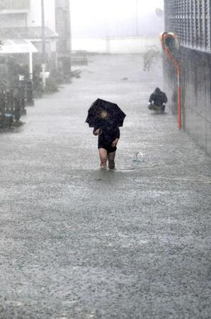 　台風１９号の影響で冠水した静岡市駿河区の道路を歩く人