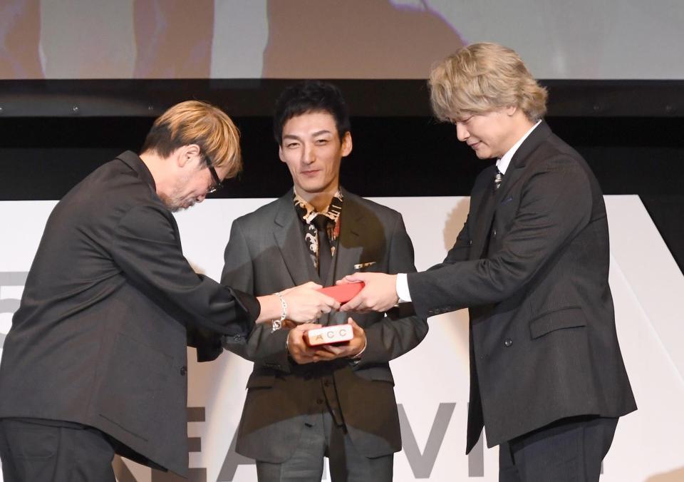 多田琢審査委員長（左）からトロフィーを渡された（右から）香取慎吾と草なぎ剛＝ＡＮＡインターコンチネンタルホテル東京（撮影・園田高夫）