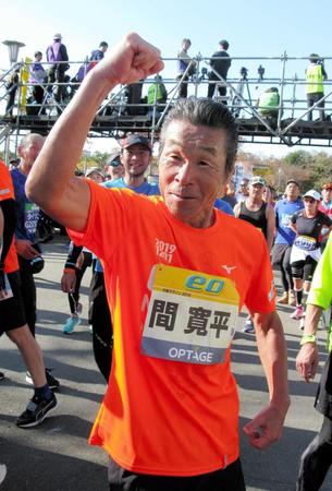 大阪マラソンを完走し、ガッツポーズする間寛平（中央）＝大阪市内