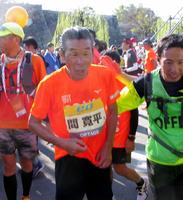 大阪マラソンを完走した間寛平（中央）＝大阪市内