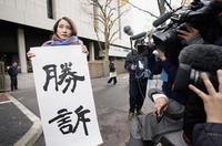 　性暴力被害を巡る訴訟の判決後、東京地裁前で「勝訴」と書かれた紙を掲げるジャーナリストの伊藤詩織さん＝18日午前