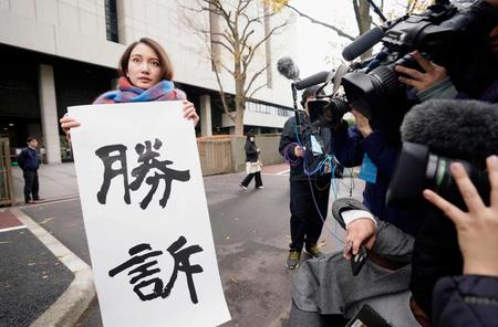 　東京地裁前で「勝訴」と書かれた紙を掲げるジャーナリストの伊藤詩織さん