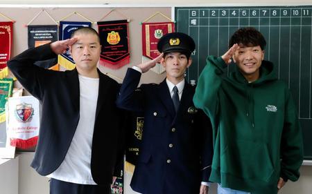 　京都府警の警察官（中央）とともに敬礼するアキナの山名文和（左）と秋山賢太（右）＝京都市・京都府立北稜高校