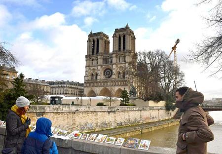 　ノートルダム寺院近くの橋の上で土産物を見る観光客ら＝パリ（共同）