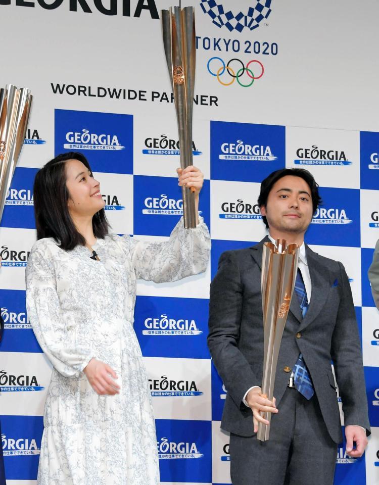 東京五輪の聖火ランナーに選出されてトーチを見つめる広瀬アリス。右は山田孝之＝東京・西新宿のパークタワーホール（撮影・堀内翔）