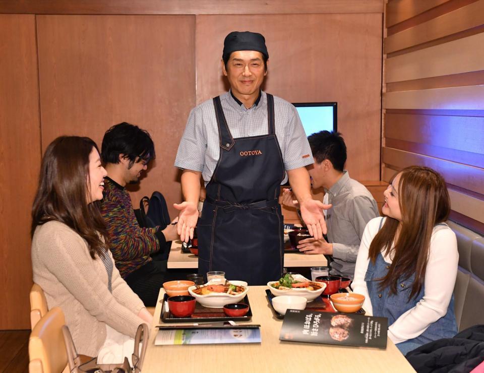 サプライズで一日店長を務め、女性客に定食を運ぶ高橋克典（中央）＝東京・西新宿（撮影・西岡正）