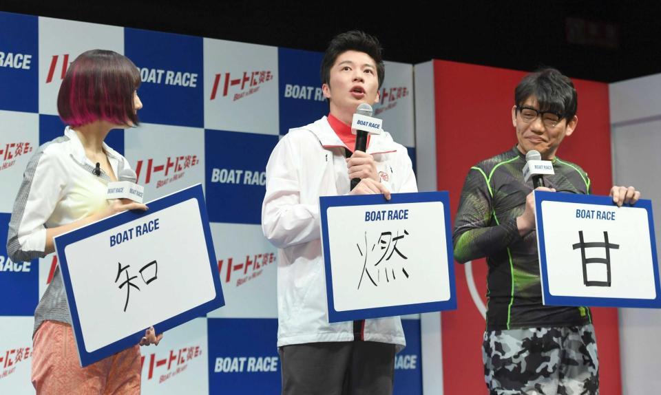 　今年の抱負を表す漢字を「燃」と記した田中圭（中央）。左は武田玲奈、右は飯尾和樹