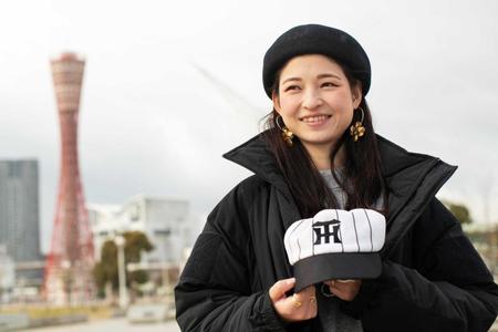 　父親の謙さんが残した阪神タイガースの帽子を持つ小島汀さん＝神戸市
