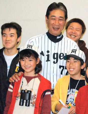 　２００２年４月、謙さんの形見の帽子をかぶり、当時、監督だった故星野仙一さんに肩を抱かれる小島汀さん（左下）＝甲子園球場