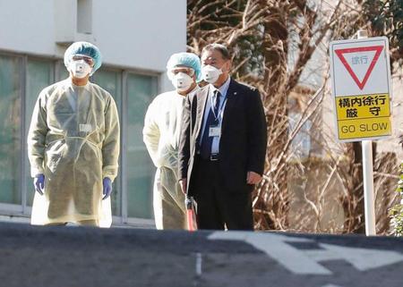 　中国・武漢からの帰国者が運ばれる国立国際医療研究センターの敷地で、マスク姿で待機する人たち＝東京都新宿区