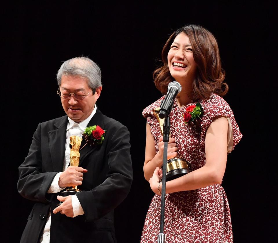 荒井晴彦監督（左）の横で笑顔のスピーチをする主演女優賞の瀧内公美＝文京シビックホール（撮影・園田高夫）