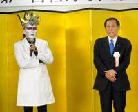 白衣姿で登場したデーモン閣下（左）。右は小島敏文政務官＝東京・霞ケ関の厚労省