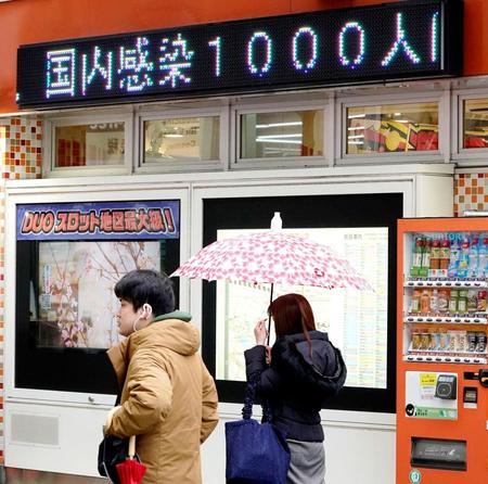 　新型コロナウイルス感染者が千人となったことを伝える電光掲示板のニュース＝東京・有楽町