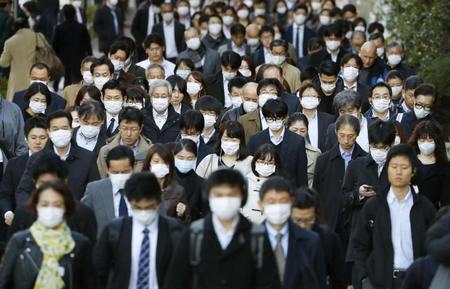 　マスク姿で通勤する大勢の人たち。ＷＨＯは新型コロナウイルス感染症について「パンデミックと表現できるとの判断に至った」と表明した＝１１日、東京都中央区