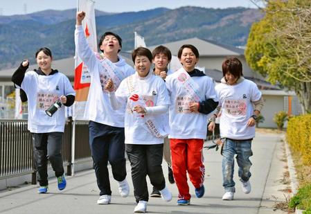　高校生らと聖火リレーのコースを走る西本由美子さん（手前中央）＝福島県広野町