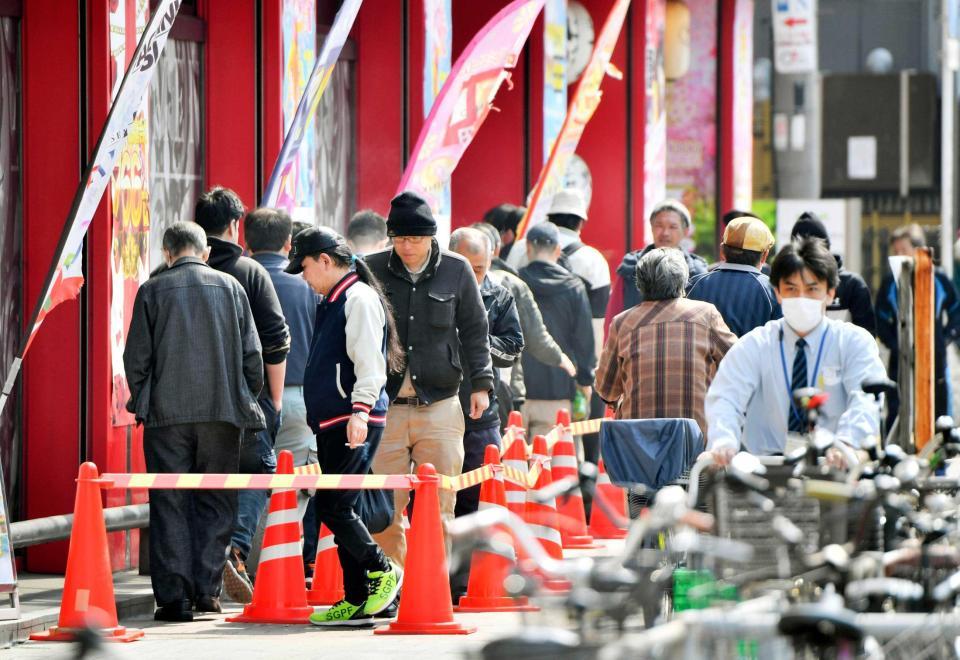 　開店前のパチンコ店に並ぶ人たち＝大阪市西成区